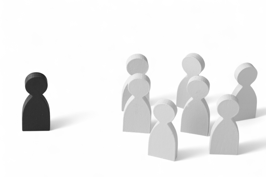 Une figurine noire devant plusieurs figurines blanches en groupe.