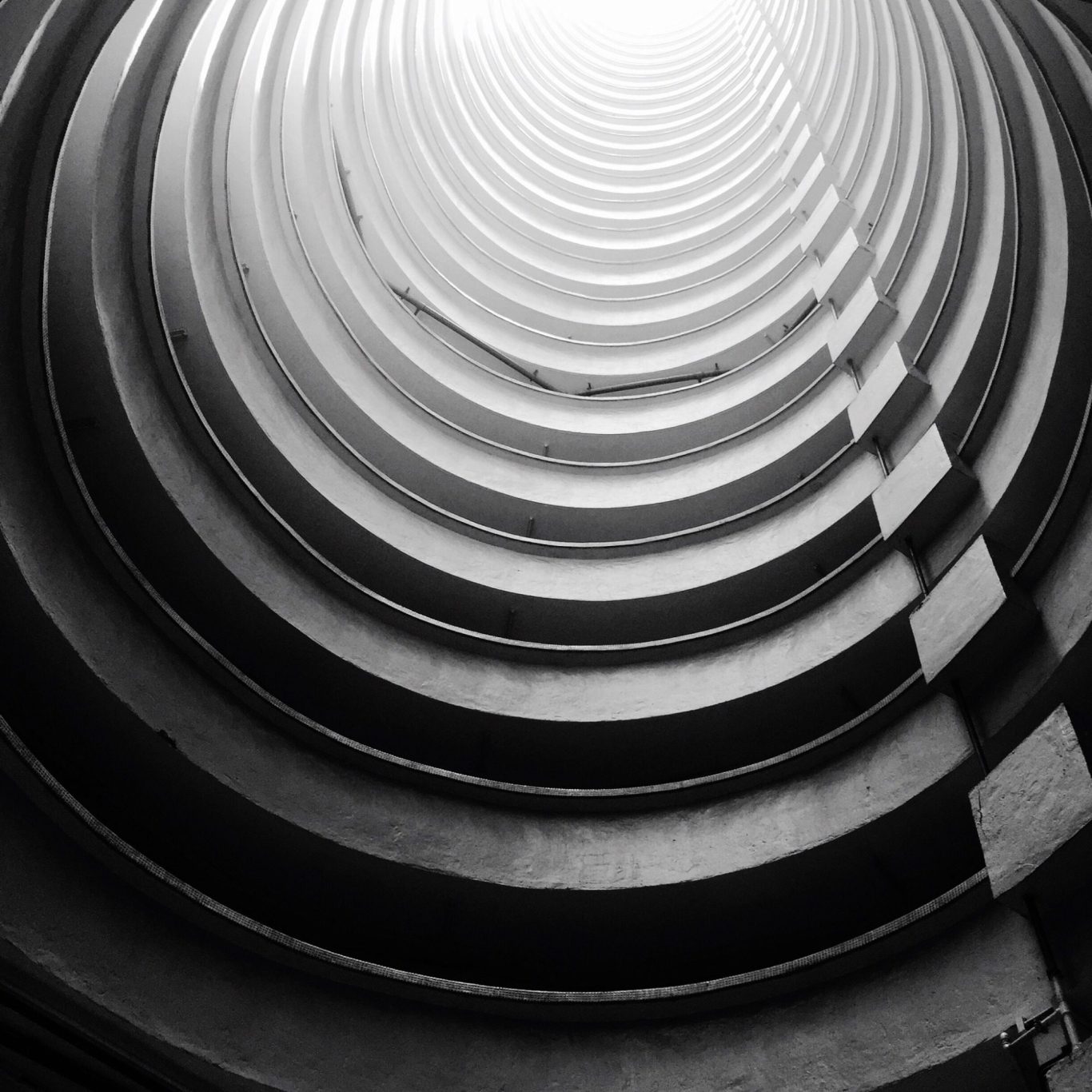 Direction marketing et communication externalisée | VISUELROUGE Photo en noir et blanc d'un escalier en colimaçon, mettant en valeur ses courbes et sa structure architecturale.