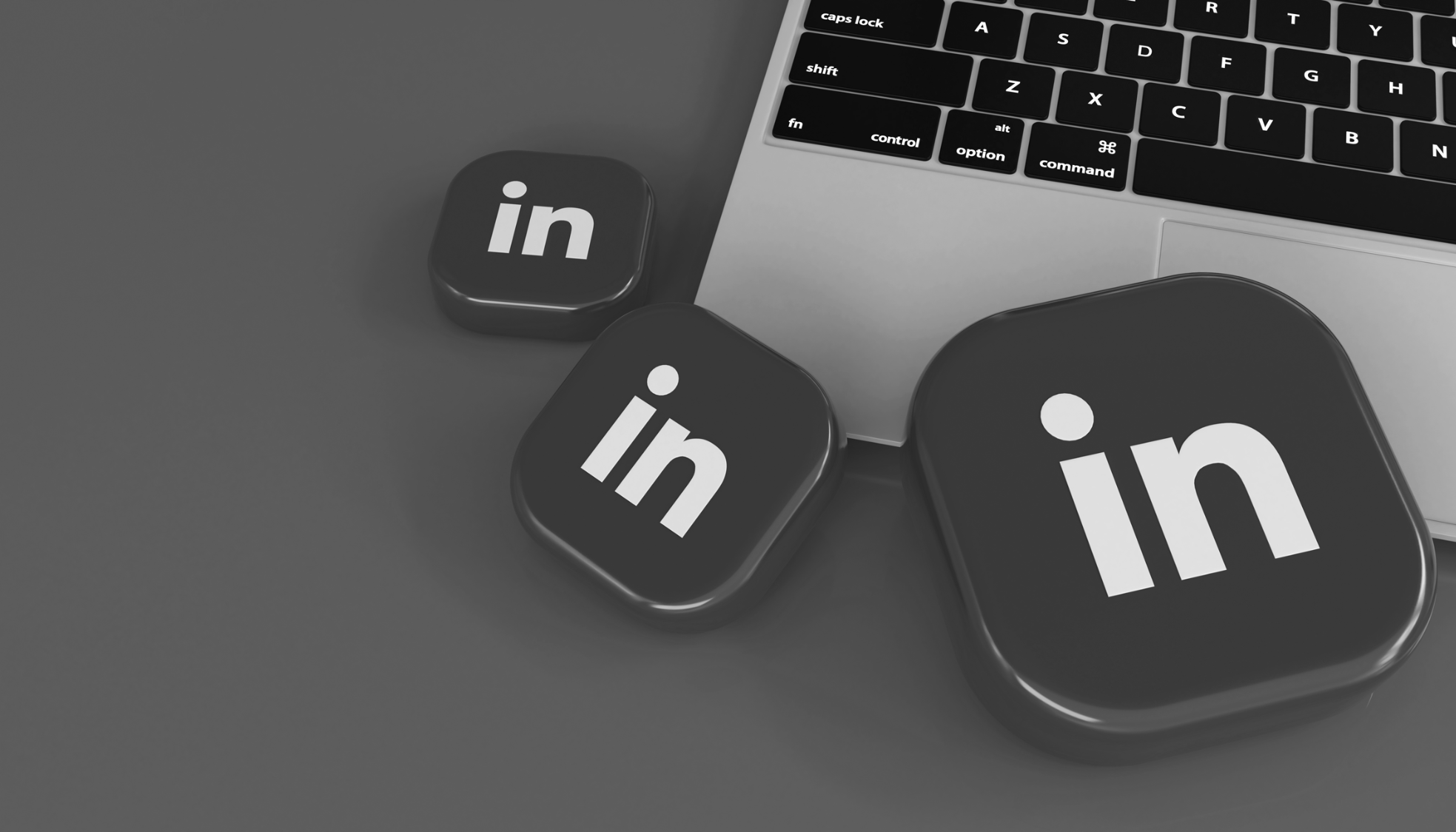 Icônes LinkedIn en noir et blanc, près d'un clavier d'ordinateur portable.