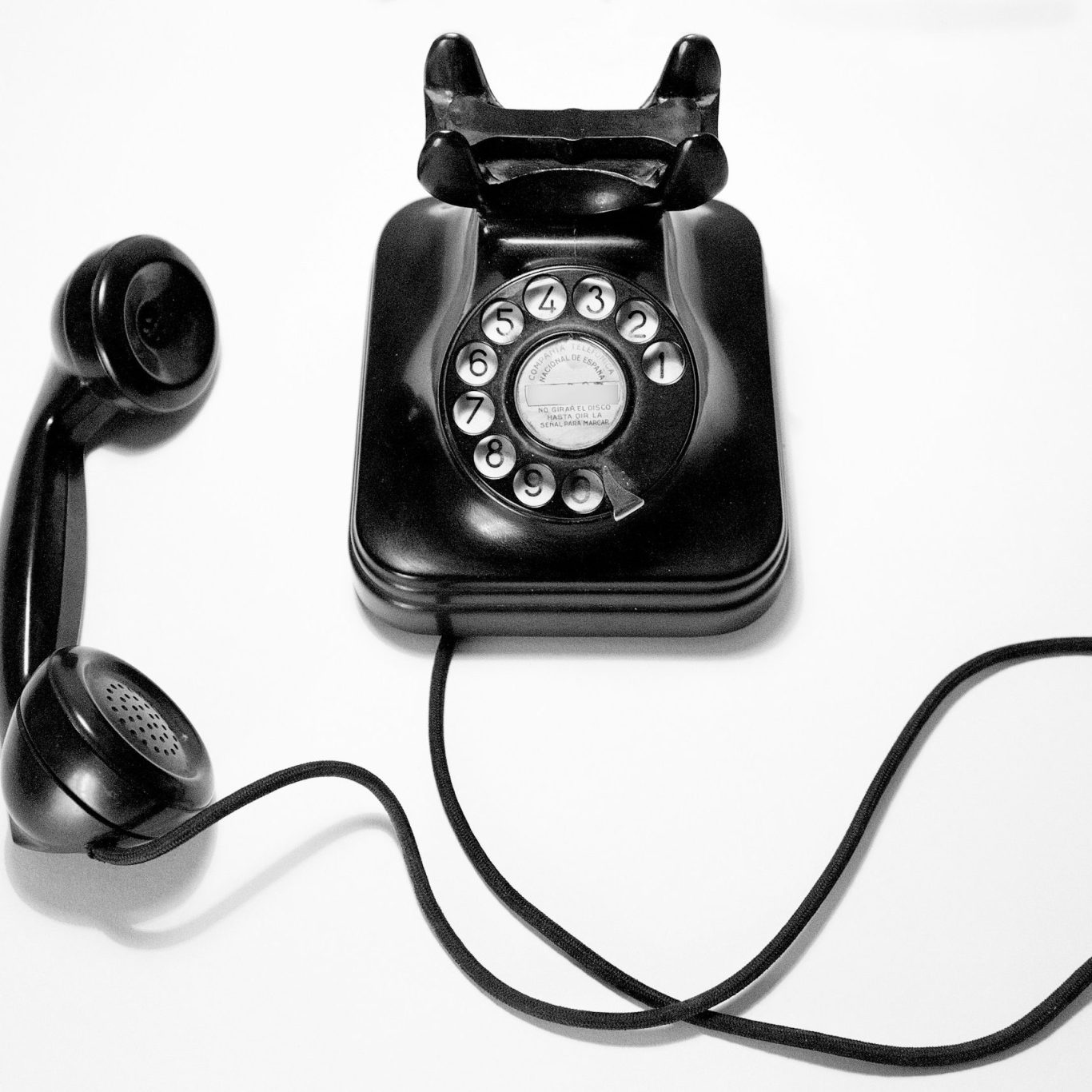 Direction marketing et communication externalisée | VISUELROUGE Un téléphone ancien avec un cordon à côté d'un téléphone sans fil moderne sur une table en bois.